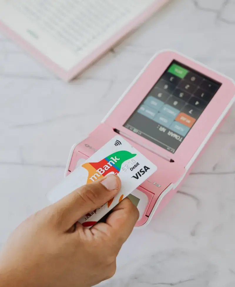 Hand hält Kreditkarte und Handy für Mobile Banking, sinnbildlich für moderne Banking-Apps in Paraguay