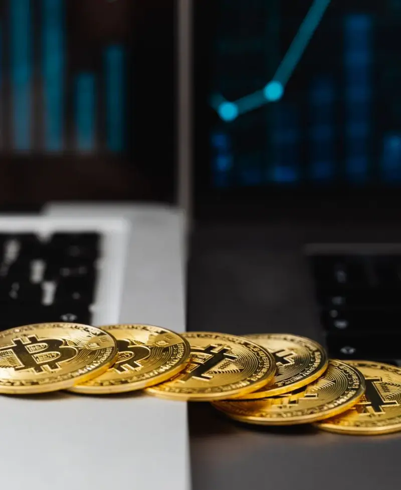 Bitcoin auf Laptop mit Finanzcharts, sinnbildlich für Krypto-basierte Zahlungen und internationales Banking als IT-Freelancer in Paraguay