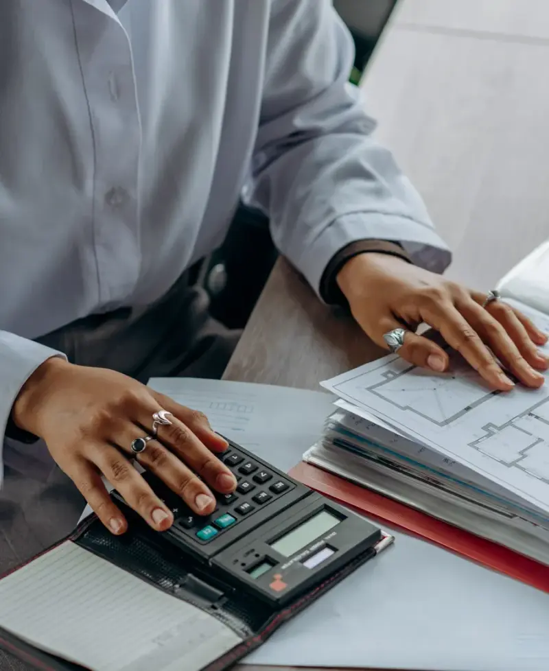 Tax-Formulare mit Taschenrechner und Stift auf grünem Untergrund, sinnbildlich für die jährliche Steuererklärung in Paraguay